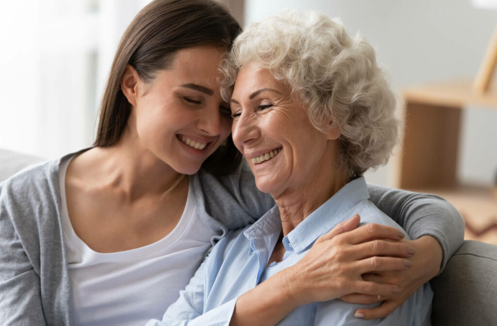An adult daughter and her elderly mother with dementia are smiling while bonding at home. it’s extra important to stay positive with them.