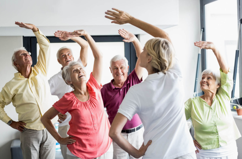 A group of seniors exercising together under the supervision of trained staff.