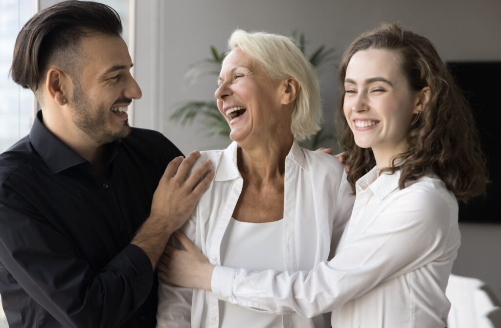 two siblings happily embracing their mature parent.